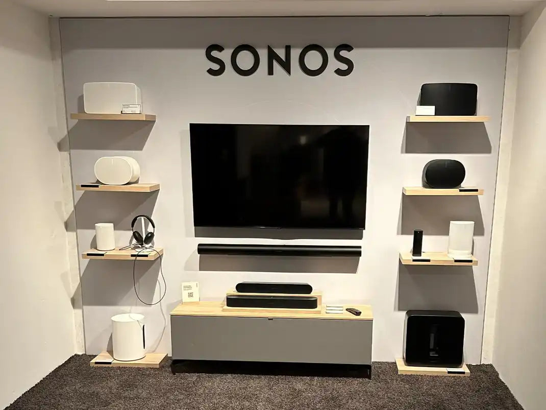 Moderne woonkamer met een tv aan de muur boven een houten mediaconsole.