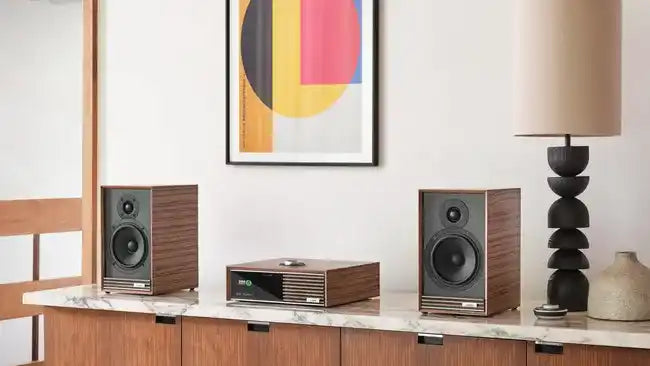Modern audiosysteem met houten boekenplankluidsprekers en een centrale versterker.