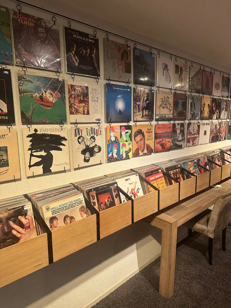 Houten vinylplaat-opbergrek met meerdere compartimenten en hangende hoezen voor display.